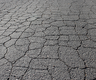 Read more about the article The Dangers of Cracked and Uneven Asphalt